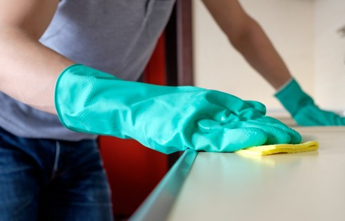 Cleaner wearing PPE while carrying out professional carpet cleaning